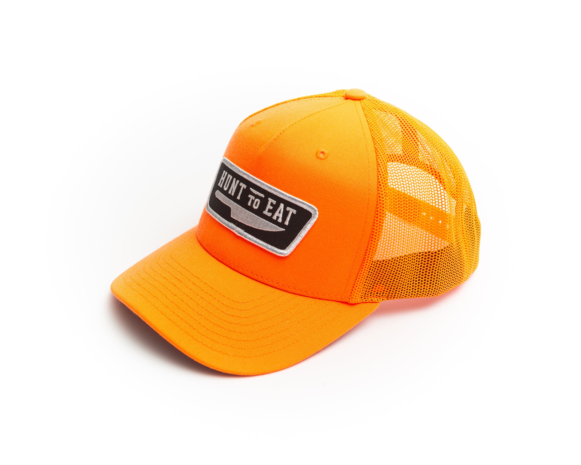 Blaze/safety Orange mesh back trucker cap.  decorated with the Hunt To Eat logo patch.  The patch contains the Hunt To Eat logo embroidered in white stitching on a black twill background surrounded by a white thread merrowed edge border. safety orange for staying visible while hunting during gun seasons. 
